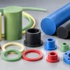 Custom colored PTFE rods and CNC machined shapes in blue, black, green, and red for visual identification in chemical processing equipment.